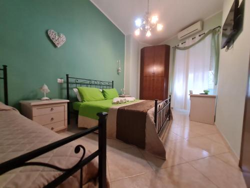 ローマにあるB&B La Casa di Gabryのベッドルーム(緑のシーツを使用したベッド2台付)