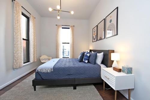 Schlafzimmer mit einem blauen Bett und einem Tisch in der Unterkunft Serenity Park Slope - Entire Brownstone apt. in Brooklyn