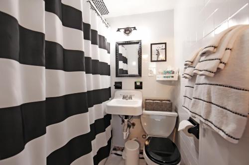 a black and white bathroom with a sink and a toilet at Serenity Park Slope - Entire Brownstone apt. in Brooklyn