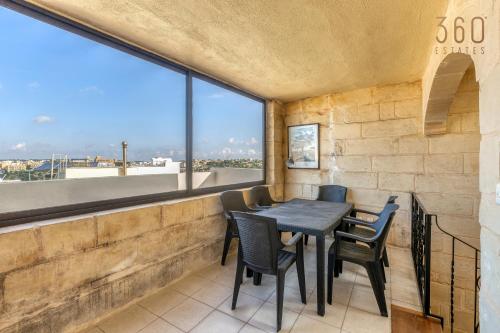 uma sala de jantar com mesa e cadeiras e uma grande janela em A 3BR characteristic home in Rabat with lovely views by 360 Estates em Rabat