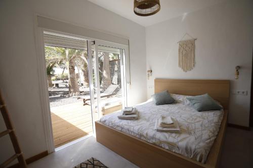 a bedroom with a bed and a sliding glass door at Casa Anahita in Lajares