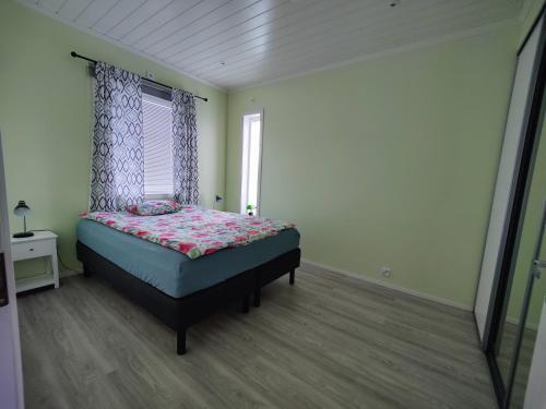 ein Schlafzimmer mit einem Bett in einem Zimmer mit einem Fenster in der Unterkunft ANDY - Perfect location in the heart of Närpes 75 m2 - Sauna - Built in 2023 in Närpiö