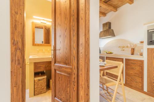 een badkamer met een houten deur naast een keuken bij CasaViva - La Dimora del Buttero in Farnese