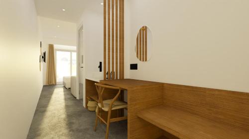 une chambre avec un bureau en bois et une chambre avec un lit dans l'établissement Pontikonisi Hotel & Suites, à Perama