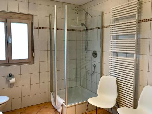 baño con ducha y 2 sillas blancas en Ferienwohnung Im Vogelsang en Sigmarszell