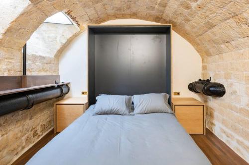 - une chambre avec un lit dans un mur en briques dans l'établissement Luxury in the heart of St Germain A/C 3 BR outdoor, à Paris