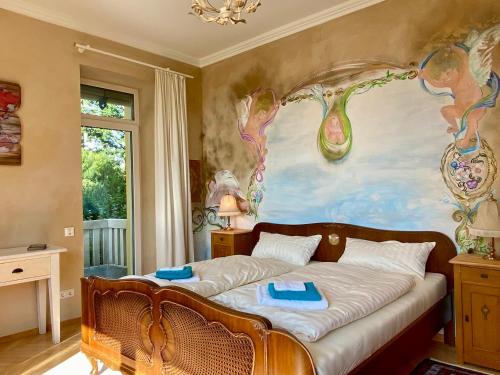 um quarto com uma cama com um quadro na parede em Villa Schwanenblick - eine besonderes Feriendomizil mit direktem Seezugang und Slipanlage em Nonnenhorn