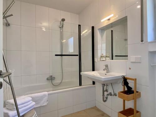 a white bathroom with a sink and a shower at Ferienwohnung Traumblick in Sigmarszell