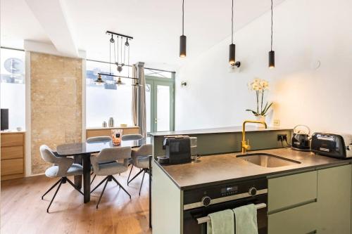 eine Küche mit einem Waschbecken und einem Tisch mit Stühlen in der Unterkunft Luxury in the heart of St Germain A/C 3 BR outdoor in Paris
