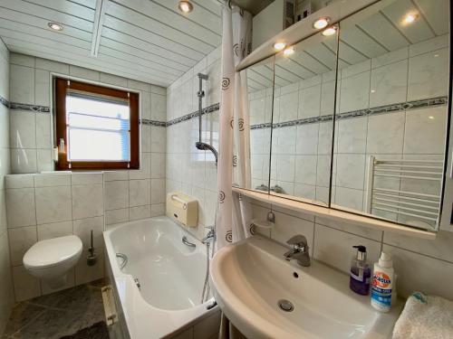 y baño con bañera, aseo y lavamanos. en Ferienwohnung Blumenoase - gemütliche Ferienwohnung zwischen Allgäu und Bodensee, en Sigmarszell