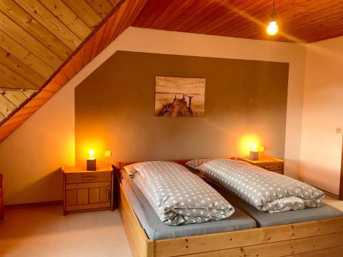 - une chambre avec un lit et 2 oreillers dans l'établissement Ferienwohnung Niedan, à Kressbronn am Bodensee