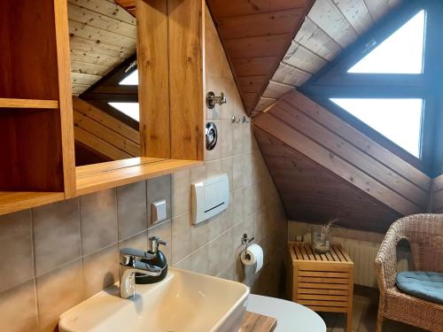La salle de bains est pourvue d'un lavabo et d'un plafond en bois. dans l'établissement Ferienwohnung Niedan, à Kressbronn am Bodensee