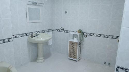 uma casa de banho branca com um lavatório e um chuveiro em CASA FAMILIAR LA ZUBIA - Granada em La Zubia