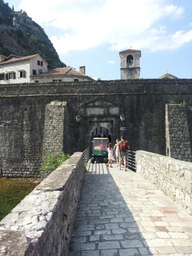 a group of people walking over a bridge with a train at Apartments Sandra in Kotor