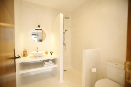 Baño blanco con lavabo y aseo en Casa Anahita en Lajares