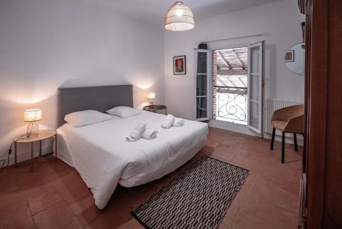 a bedroom with a white bed and a balcony at Gîte du chemin des Dames in Montauban