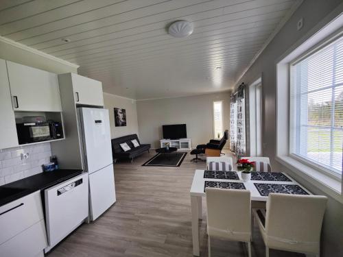 een keuken en woonkamer met een tafel en stoelen bij ANDY - Perfect location in the heart of Närpes 75 m2 - Sauna and AC - Built in 2023 in Närpiö