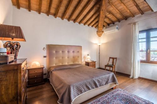 1 dormitorio con 1 cama grande y techo de madera en Podere Palazzetto, en Buonconvento