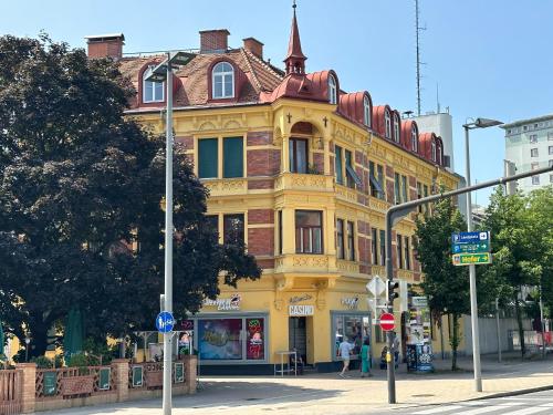 un edificio amarillo en la esquina de una calle en Stilvolles Apartment im Zentrum en Graz