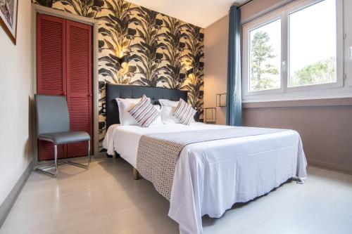 a bedroom with a large bed and a chair at The Originals City, H&ocirc;tel Rive Droite, Albi "Quartier Madeleine" in Albi