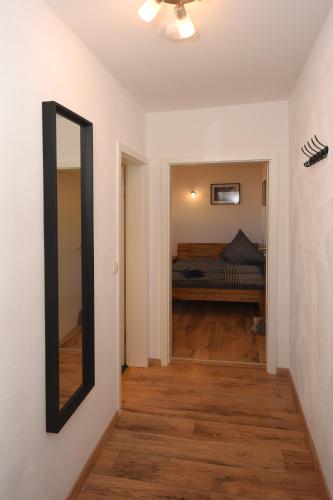 a hallway with a mirror and a bed in a room at Ferienwohnung am Rathaus in Landstuhl
