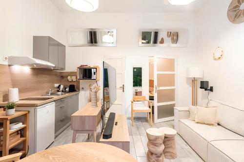 une cuisine et un salon avec un canapé et une table dans l'établissement Secret Jungle Bordeaux Chartrons - Hyper-Centre Jacuzzi Bain Balnéo & Home cinéma, à Bordeaux