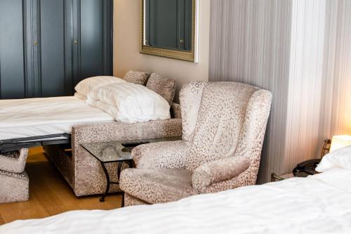 a bedroom with a bed and a chair and a desk at Hotel Du Lac & SPA in Bellagio