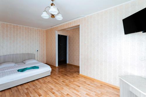 1 dormitorio con 1 cama y TV de pantalla plana en Варна, en Petropavlovsk