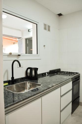 a kitchen counter with a sink and a mirror at La Isabel in Esquel
