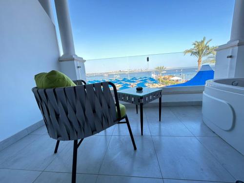 Naama Bay Suites & SPA في شرم الشيخ: كرسي وطاولة في غرفة مع مسبح