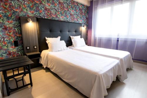a bedroom with a large bed with a large white blanket at The Originals City, Hôtel Rive Droite, Albi "Quartier Madeleine" in Albi