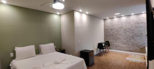 a bedroom with a bed and a brick wall at Pousada Banana Cipó in Serra do Cipo