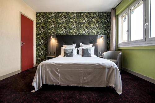 a bedroom with a large white bed and a chair at The Originals City, Hôtel Rive Droite, Albi "Quartier Madeleine" in Albi