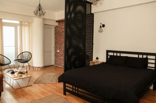 a bedroom with a black bed in a room at Studio Zeus in Neptun