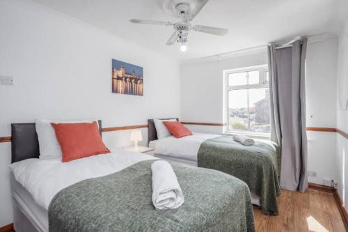 1 dormitorio con 2 camas y ventana en Cosy 3 BDR Home With Wifi, Parking + Garden, en Tilbury