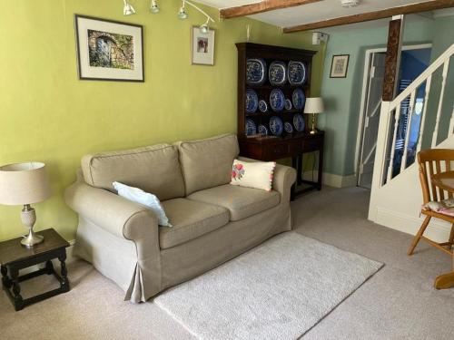 a living room with a couch and a table at Lemon Cottage in Hatherleigh