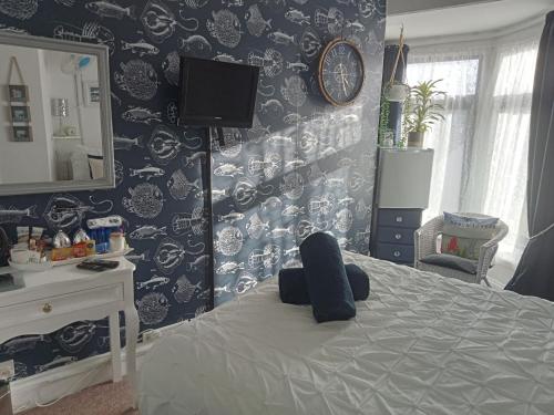 a bedroom with a bed and a mirror at Marjune Guest House in Weymouth