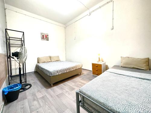 - une chambre avec 2 lits et une commode dans l'établissement Sri-Indo Guest House, à Lisbonne