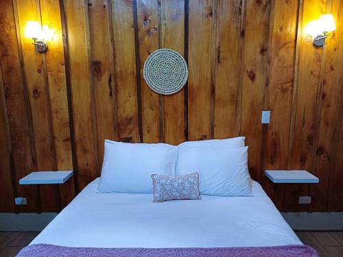 a bed with white sheets and a pillow on it at Les Chalets Costa Rica in Zarcero