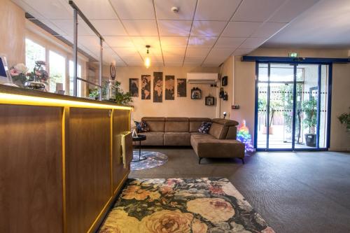 a living room with a couch and a table at The Originals City, Hôtel Rive Droite, Albi "Quartier Madeleine" in Albi
