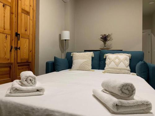- une chambre avec un lit et des serviettes dans l'établissement El Alma de Granada 2, à Grenade
