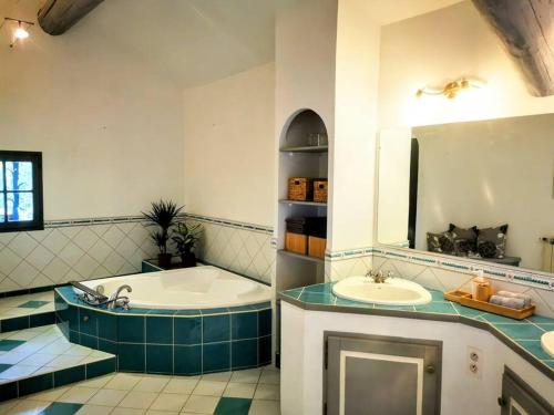 y baño con 2 lavabos, bañera y espejo. en Mas en Provence, en campagne avec piscine., en Orange