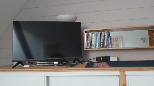 einen Flachbild-TV auf einem Tisch in der Unterkunft Herbes et collines in Winkel