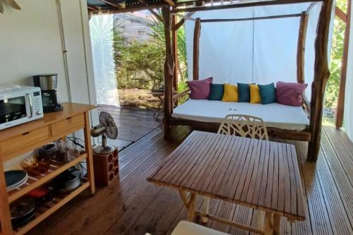 a porch with a couch and a table at Bungalow atypique Ti Bambou à 500m de la plage in Sainte-Anne