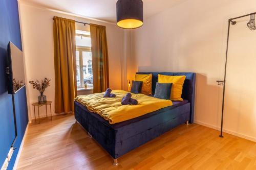 a blue bed with yellow sheets and pillows in a room at *NEU* 2 Personen, WLAN, Balkon in Pirna