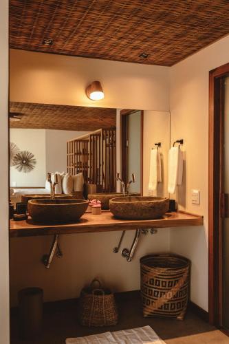 a bathroom with two sinks and a mirror at Pousada Moana in Fernando de Noronha