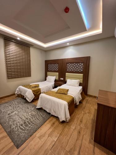 Cette chambre comprend 3 lits et un tapis. dans l'établissement شاليهات وايت هافن - ابها, à Khamis Mushait