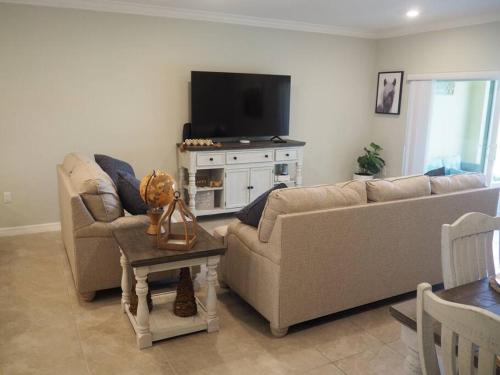a living room with a couch and a tv at Luxurious Farm Style House in Kissimmee