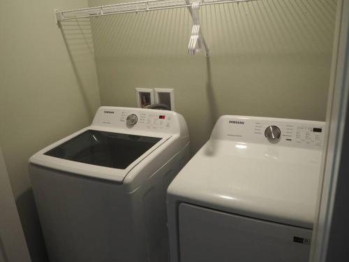 a laundry room with a washing machine and a washer at Luxurious Farm Style House in Kissimmee