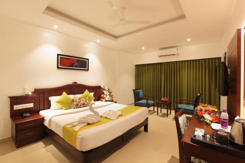 Ettumānūr的住宿－National Park residency，一间卧室配有一张床和一张书桌,另一间卧室配有一张桌子。